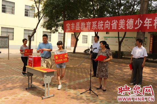 寶豐縣教育系統(tǒng)全體人員在石橋鎮(zhèn)中學(xué)為“美德少年”楊冠明同學(xué)捐款。