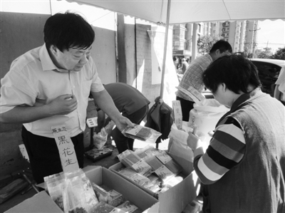 昨日，河南企業(yè)家劉春喜在京“練攤”，為顧客挑選綠豆。新京報(bào)記者 張玉學(xué) 攝