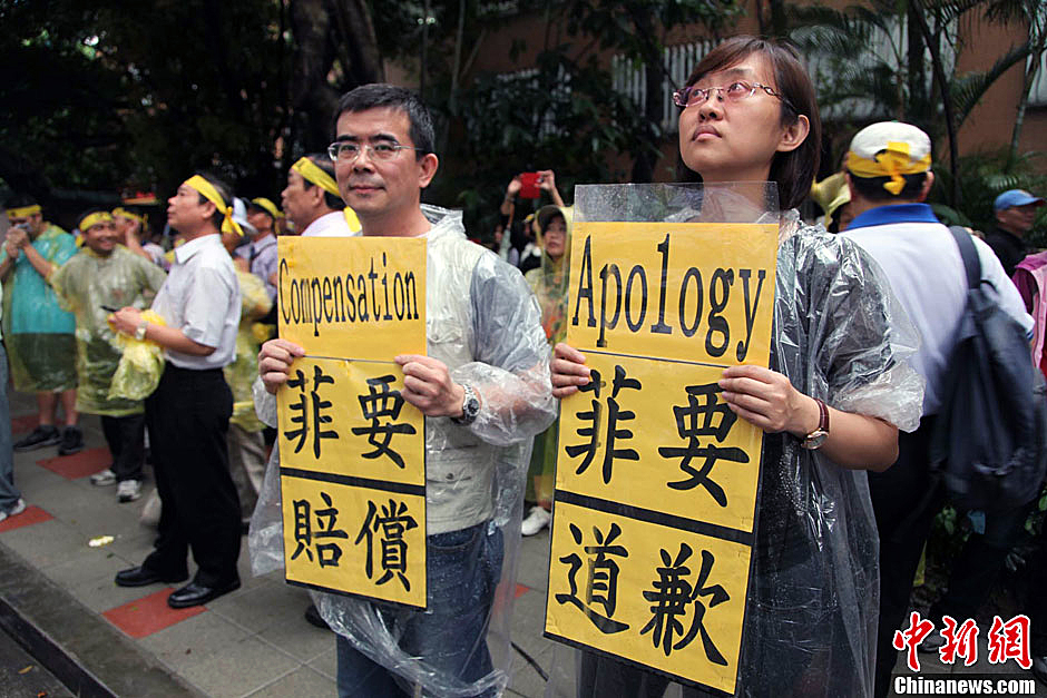 　圖為當(dāng)天下午，當(dāng)臺(tái)灣數(shù)百漁民在馬尼拉經(jīng)濟(jì)文化辦事處前抗議時(shí)，有兩名年輕人手持標(biāo)語，在路邊聲援。中新