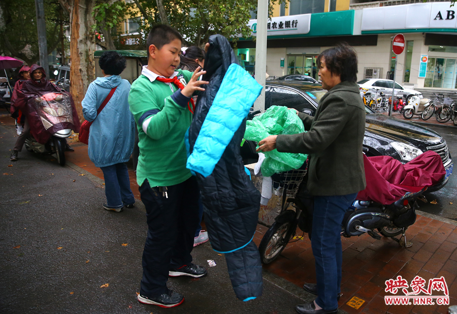 學(xué)校門口，家長給孩子帶來了御寒的厚衣服。