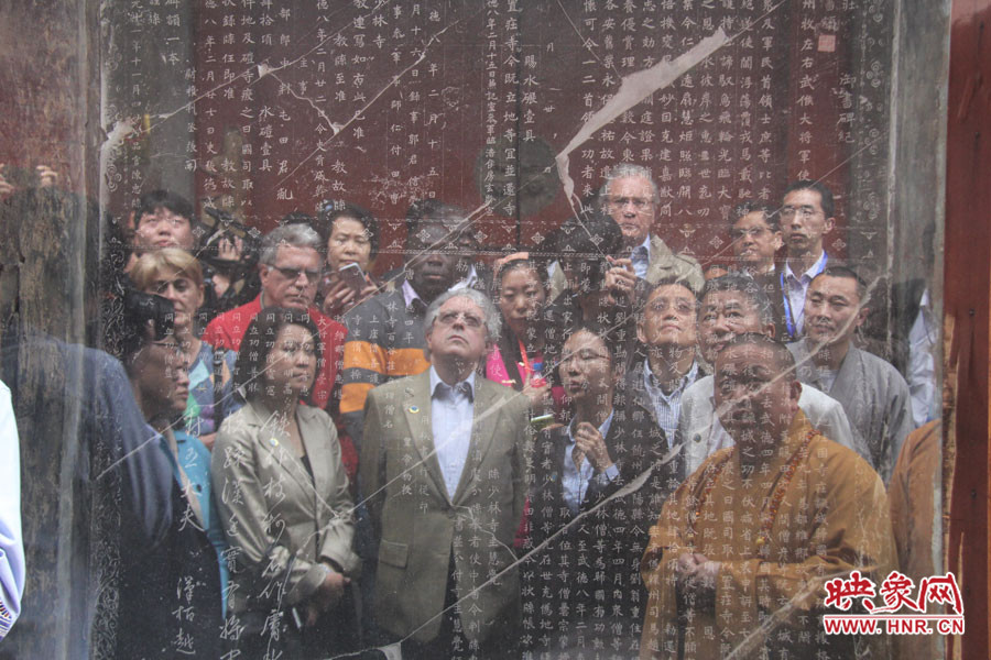 在一塊石碑前，少林寺方丈正在講解