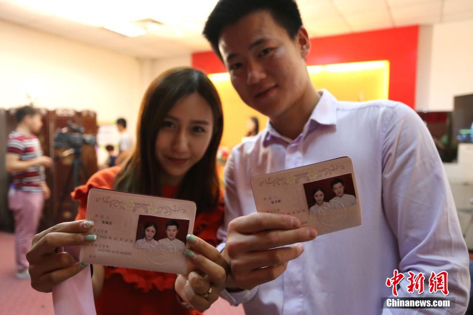 5月20日,河南鄭州,一對(duì)準(zhǔn)新人領(lǐng)完結(jié)婚證后秀自拍。