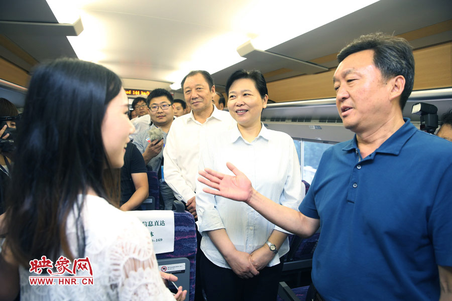 6月26日,首發(fā)的鄭焦動(dòng)車上,副省長王艷玲(右二)和乘客交流