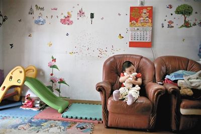 6月14日，未婚媽媽于軍的家里。女兒悅悅抱著兔子玩偶，在聽媽媽手機上的兒歌，這個4歲女孩喜歡兔子。