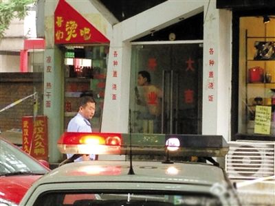 闖入面館的持刀男子與趕來的民警隔著玻璃門對峙，后店內(nèi)一名女童被其劫持。網(wǎng)友供圖