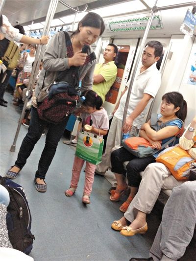 6月27日，舒馨帶一女孩在地鐵十號線行乞。她因被疑帶多個不同小孩乞討被警方搜尋。新京報記者 申志民 攝