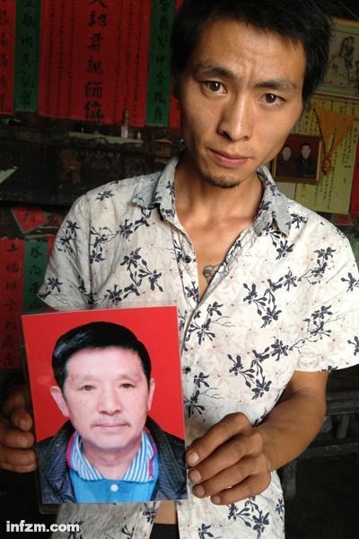 程興貴的兒子程正鵬拿著父親的遺照。程興貴自殺后，政府補償程家6000多塊錢，并終于認定了程興貴的代課教齡。 (南方周末記者雷磊/圖)