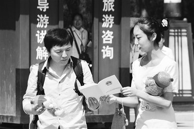 9月13日，西安臨潼華清池景區(qū)服務人員向游客介紹《旅游法》。