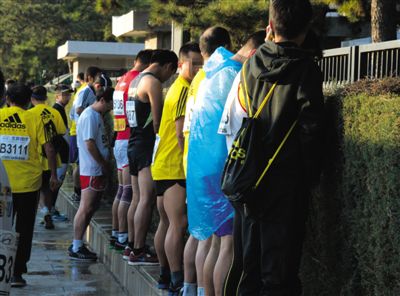 2013年10月20日，北京馬拉松比賽，由于廁位有限，一些選手在綠化帶“就地解決”。圖/IC