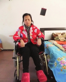 陳慶霞坐在輪椅上。她現(xiàn)在下身癱瘓，疾病纏身，生活不能自理。