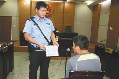 昨日庭審中，法警向趙某出示其扎完車胎后所留辱罵公司的紙條。通訊員 李秀文 攝