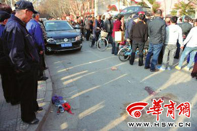 車禍現(xiàn)場的血跡被人用土覆蓋，旁邊則放著紅領巾、一雙童鞋和一頂帽子 本報記者 趙彬 攝