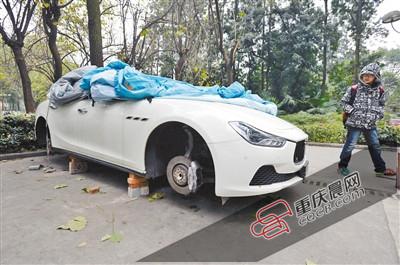 昨日，停放在重慶大學(xué)B區(qū)的一輛瑪莎拉蒂豪車被架在幾塊磚頭上，車輪不翼而飛。 重慶晨報(bào)記者 胡杰 攝