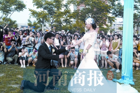 在學(xué)校操場的草坪上，兩名畢業(yè)生舉行婚禮，有同學(xué)感動地抹起眼淚