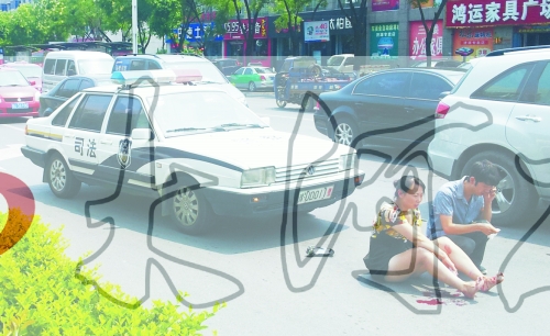事故發(fā)生后，警車司機(jī)（右）下車查看傷者并撥打120，倆“領(lǐng)導(dǎo)”穩(wěn)坐車內(nèi)引發(fā)圍觀者不滿。
