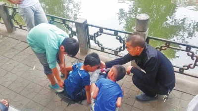 男孩被救出后，圍觀群眾幫他控水換衣服。