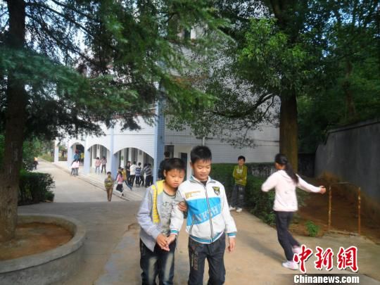 4年來，13歲的余興泉（左一）每天都攙扶著腿腳不便的同學(xué)左臣進(jìn)出教室、食堂和廁所。 李俊杰 攝