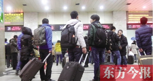 鄭州火車站東廣場(chǎng)售票大廳，幾名學(xué)生在售票窗口前躊躇