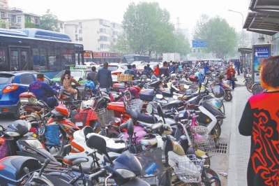 省人民醫(yī)院北門，路邊的公交站牌處停滿非機動車，上、下客只能在快車道上。