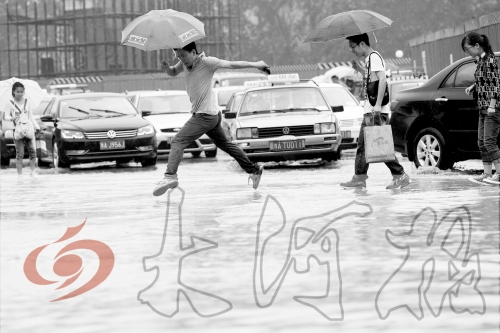 鄭州經(jīng)三路與北環(huán)交叉口處，積水較深，行人們不得不“練輕功”。 記者 白周峰 攝影