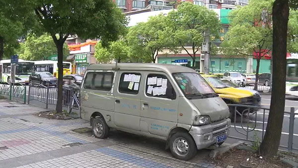 被棄置在人行道上的面包車(chē)。