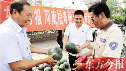 河南福壽園區(qū)域總經(jīng)理吳正宗（左一）、東方今報(bào)發(fā)行中心副總監(jiān)王路喜（中）在街頭給市民送瓜