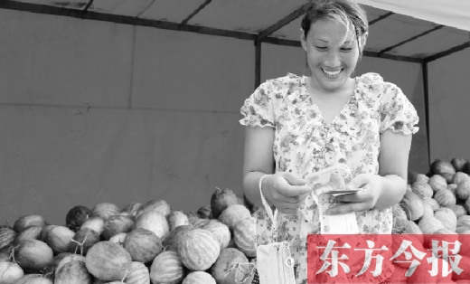 昨日，開(kāi)封瓜農(nóng)史瑩瑩幸福地?cái)?shù)著賣瓜錢 東方今報(bào)記者 沈翔 攝
