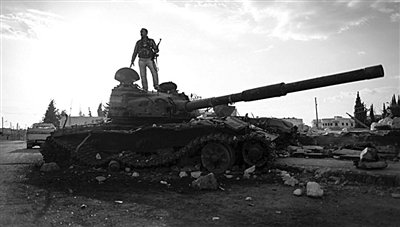 9月8日，敘利亞Zabadani，一名敘利亞反對派武裝人員站在廢棄的政府軍坦克上。
