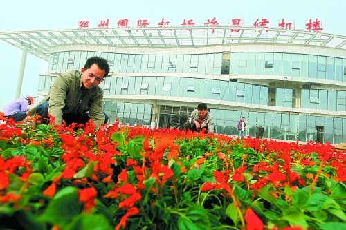 9月23日，工人們正在鄭州國際機場許昌候機樓前擺放鮮花。