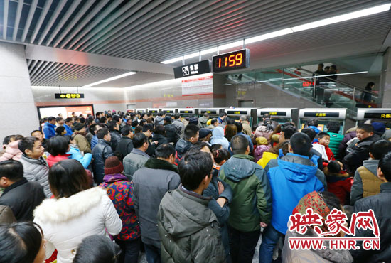 地鐵開通首日，上午十一點五十九分，紫荊山地鐵站售票機前擠滿了買票的市民。