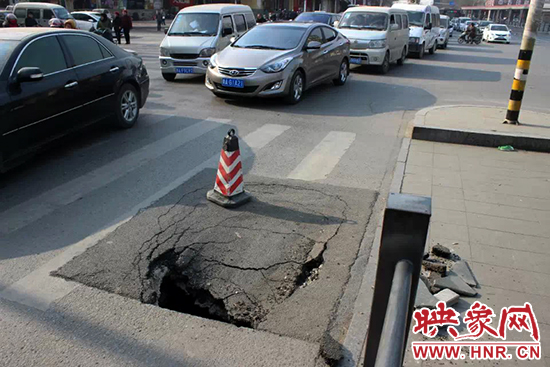 南陽(yáng)路農(nóng)業(yè)路出現(xiàn)深坑，近看是因?yàn)闉r青充當(dāng)窨井蓋所致