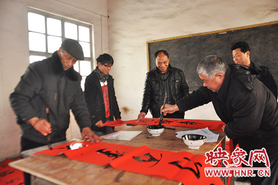 鞏義市魯莊鎮(zhèn)農(nóng)民書法愛好者正在寫春聯(lián)。