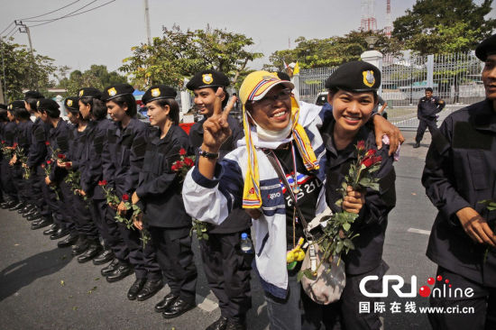 2013年12月03日,曼谷總理府與曼谷警署允許反政府示威民眾進(jìn)入,雙方進(jìn)入暫時(shí)“停戰(zhàn)”狀態(tài)迎接泰王生日。曼谷警察總署,女警們手持鮮花送給反政府示威民眾。圖片來源:Manish Swarup/東方IC