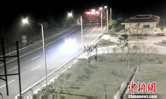 看到車輛經(jīng)過，孩子們便急忙跑到一旁的花圃上?！【焦﹫D　攝