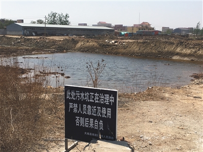 化肥廠滲坑的三分之一經(jīng)過(guò)治理，但水質(zhì)仍然呈黃褐色。