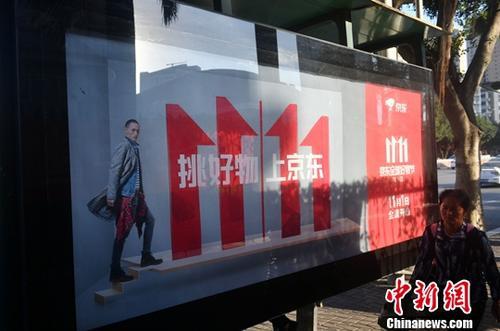 資料圖：11月1日，福州民眾從雙十一廣告牌前經(jīng)過。中新社記者 呂明 攝
