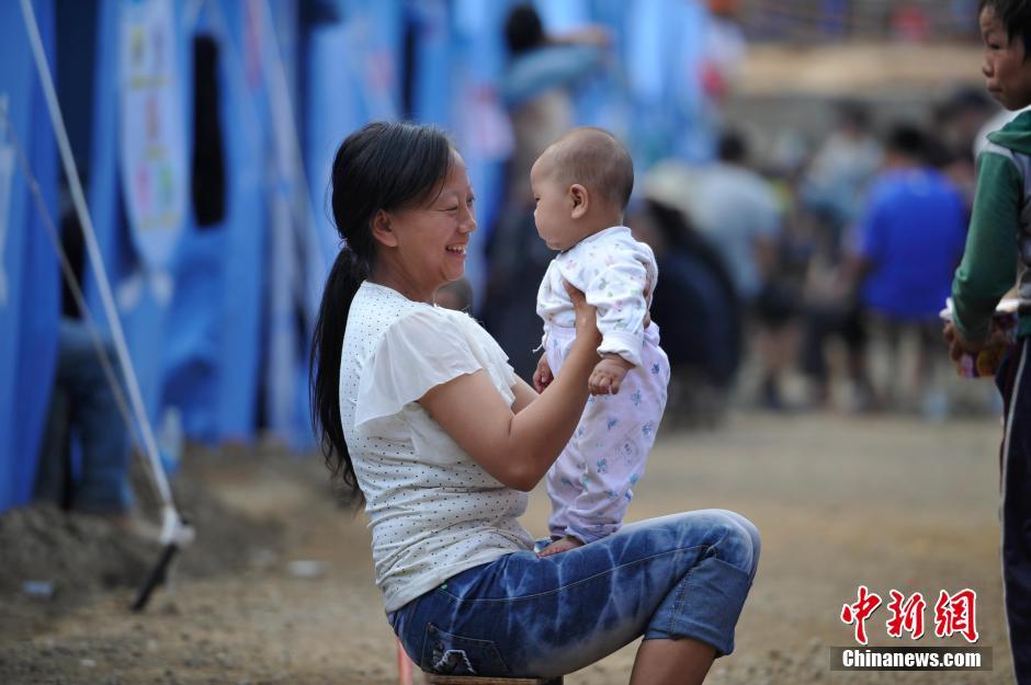 8月6日，一名年輕的母親在和孩子玩樂。