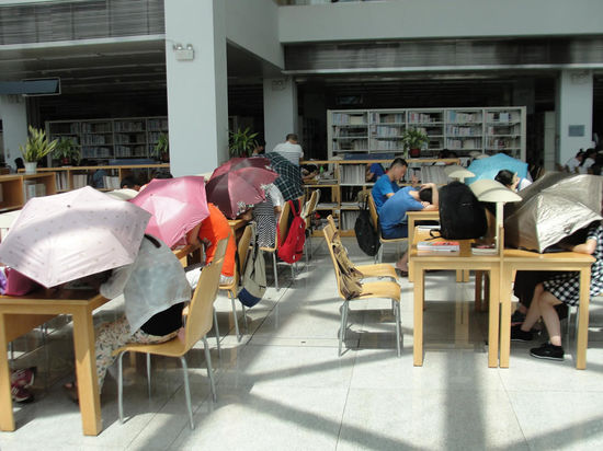 圖書館內(nèi)撐傘讀書的民眾。