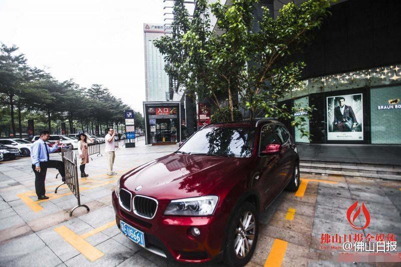 一輛停在停車位上的寶馬轎車，被墜落的樹枝砸中，樹枝徑直插入車內(nèi)，現(xiàn)場(chǎng)引發(fā)不少市民圍觀拍照。
