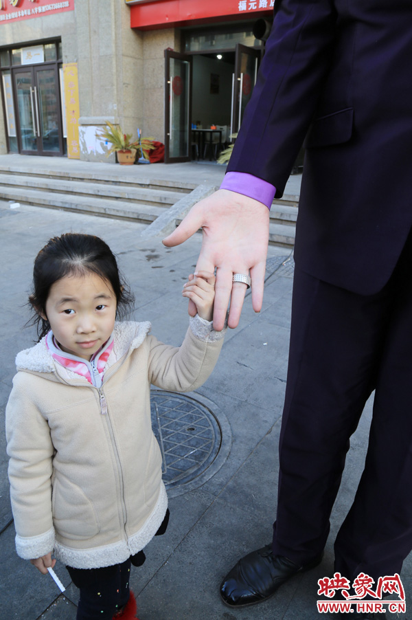 巨人“張歡”牽著一名漂亮的小女孩，兩人的手大小對(duì)比非常明顯。