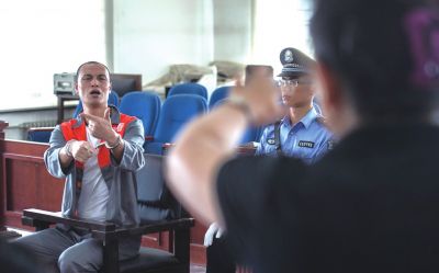 張志國(guó)在法庭上用手語(yǔ)回答提問(wèn)。記者 蒲東峰攝