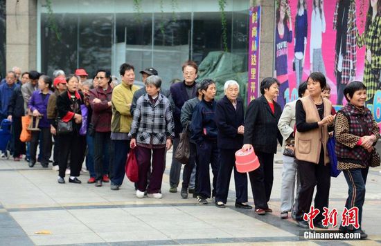 圖為10月28日，在江西九江市一家羊絨皮草服裝服飾博覽會(huì)現(xiàn)場(chǎng)，老人們正在頂著寒風(fēng)排隊(duì)等待領(lǐng)取10元代金劵。
