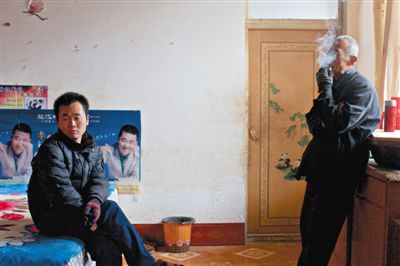 父親抽煙，兒子不語。逃跑的越南新娘，給袁迎賓父子帶來的是失落。新京報(bào)記者 周崗峰 攝